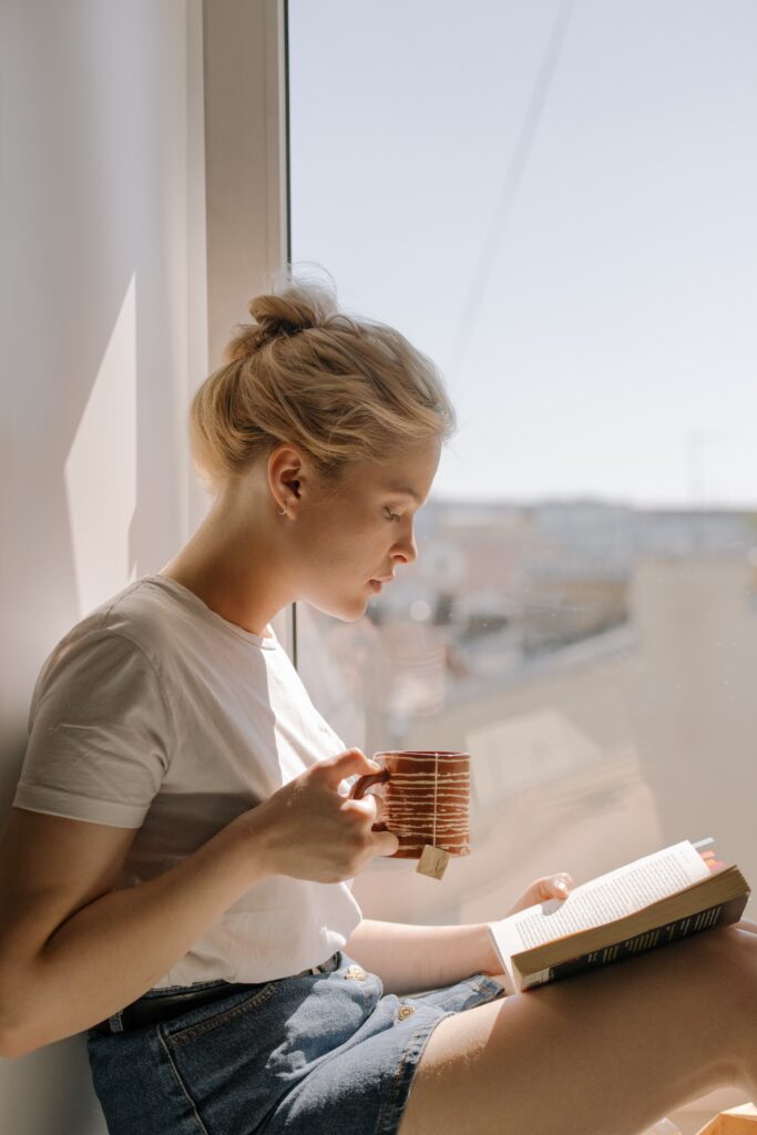 Woman drinking coffee in window